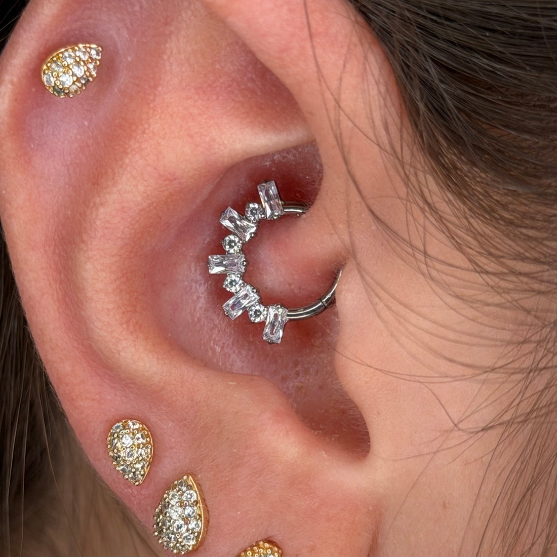 Piercing clicker in titanio ASTM F136 con zirconi taglio baguette. Ideale per daith e septum, leggero, biocompatibile e resistente. Eleganza e brillantezza per ogni occasione.