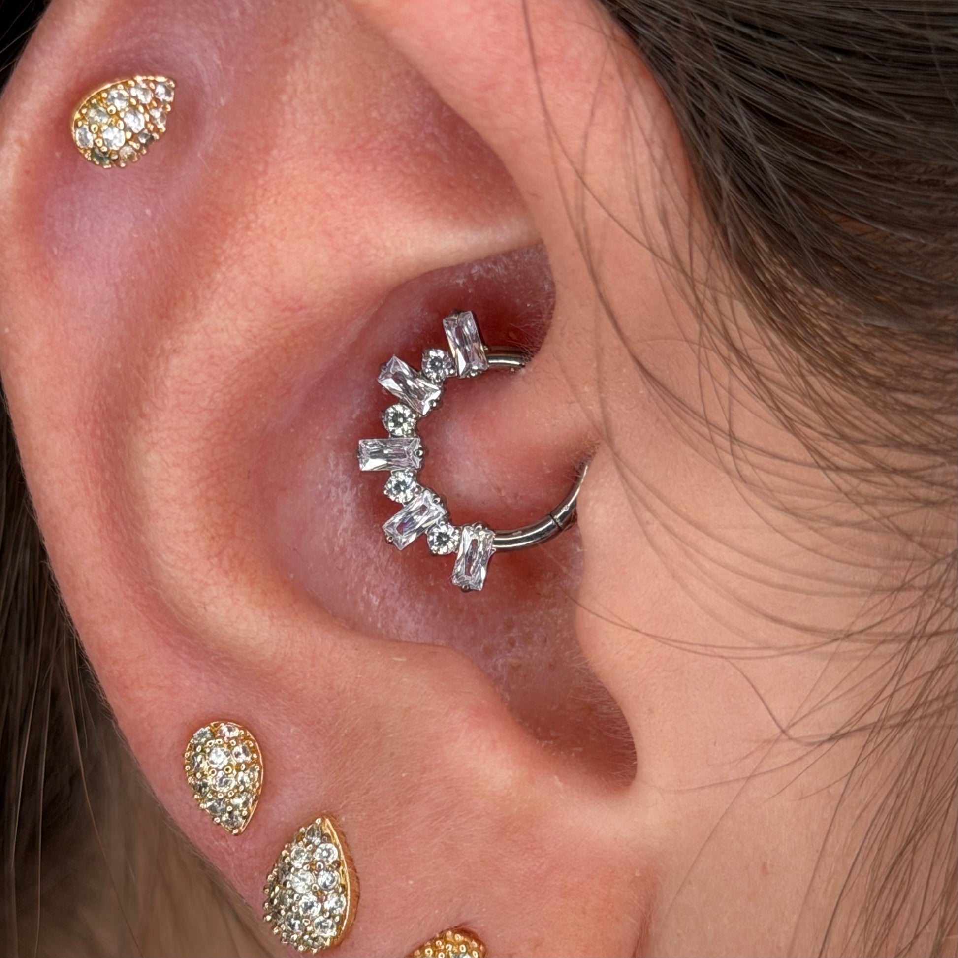 Piercing clicker in titanio ASTM F136 con zirconi taglio baguette. Ideale per daith e septum, leggero, biocompatibile e resistente. Eleganza e brillantezza per ogni occasione.