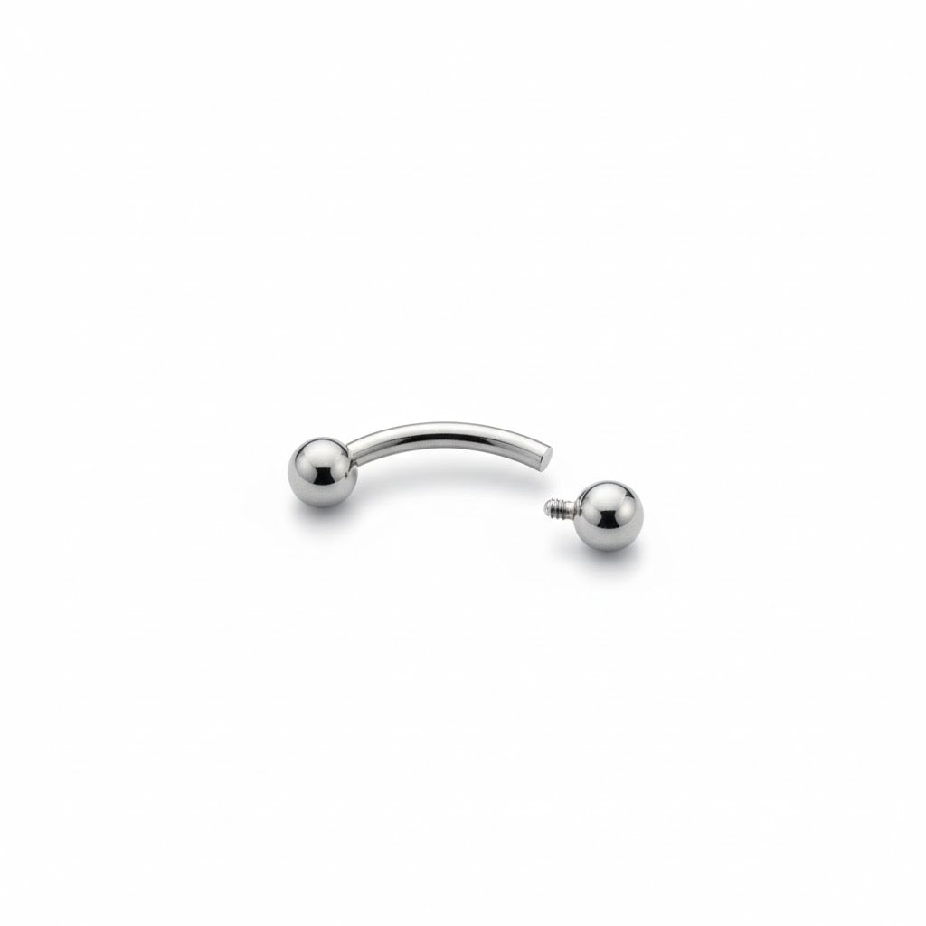 Piercing a bananina (curved barbell) in titanio di grado implantare, con palline a vite. Barra curva ipoallergenica per piercing all'ombelico, sopracciglio o rook. Disponibile in diverse lunghezze.