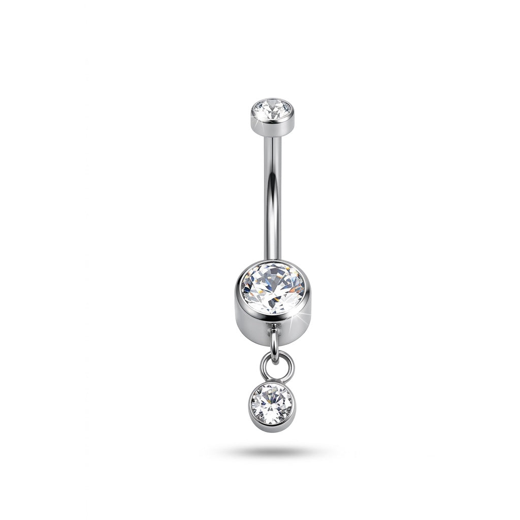 Piercing da ombelico in Titanio ASTM F136 dal design elegante e luminoso. La pietra centrale è arricchita da un delicato pendente con cristallo, creando un effetto raffinato e leggermente movimento sul piercing.
Perfetto per chi cerca un navel piercing con pendente elegante e versatile, capace di aggiungere un piccolo punto luce senza risultare eccessivo.