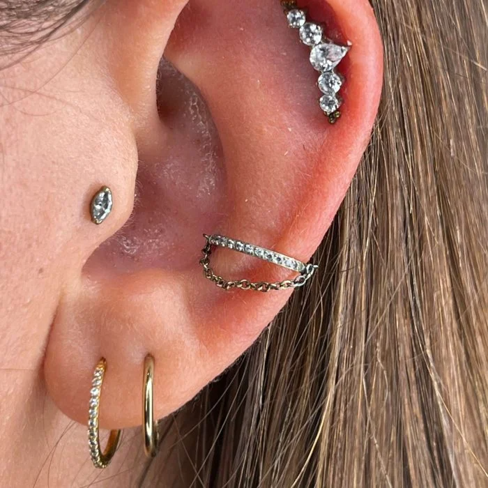 Cerchietto clicker (hinged ring) in titanio di grado implantare, con catenella pendente (Bright Clicker Chain). Chiusura a scatto, anello con dettaglio catena