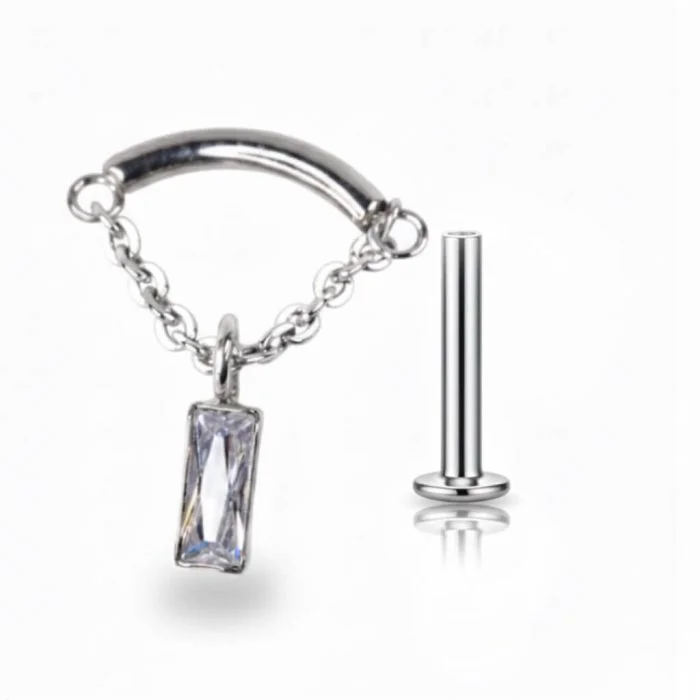 Gioiello pendente "Chain Rectangle" in titanio di grado implantare, composto da una catenella sottile con cristallo a forma di quadrato. Perfetto per piercing Hidden Helix, ma adatto anche a lobo e flat. Stile moderno ed elegante.