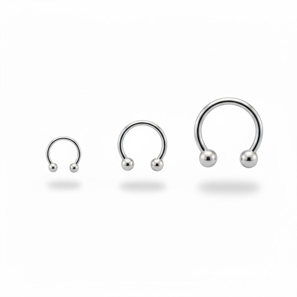 Piercing a ferro di cavallo (circular barbell) in titanio di grado implantare, con palline a vite. Anello base ipoallergeni. Disponibile in diverse misure.
