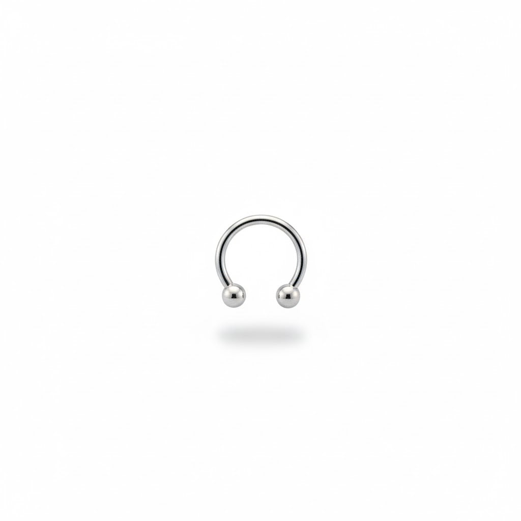 Piercing a ferro di cavallo (circular barbell) in titanio di grado implantare, con palline a vite. Anello base ipoallergeni. Disponibile in diverse misure.
