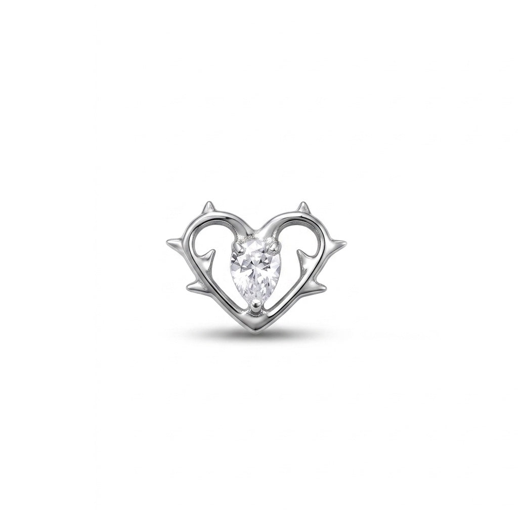 Gioiello per piercing realizzato in titanio, caratterizzato da un elegante design a cuore con dettagli effetto ali e piccoli cristalli luminosi. Un modello romantico e originale, perfetto per valorizzare diversi piercing dell’orecchio con un tocco delicato ma particolare.