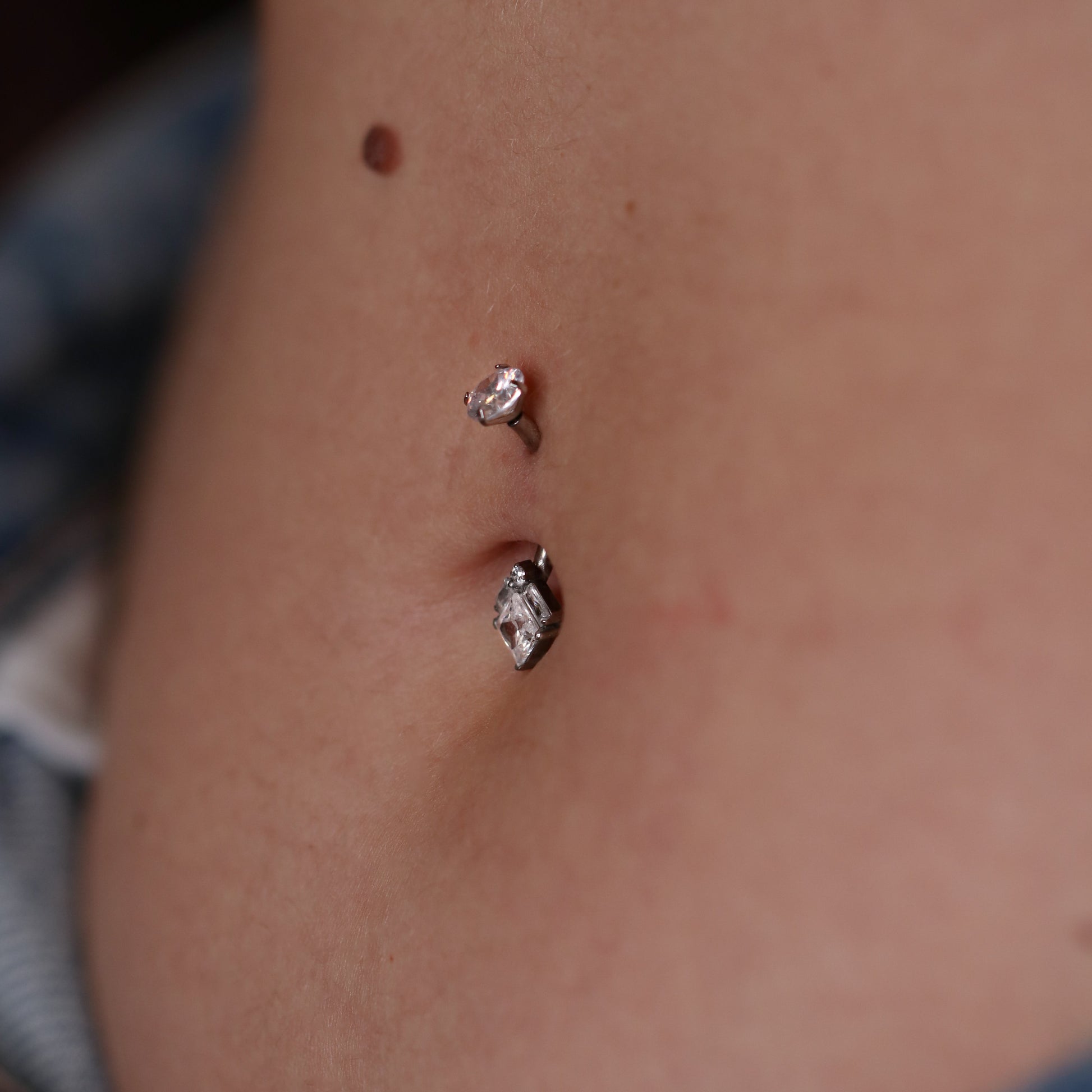 pendente principale è composto da un maestoso cristallo taglio Princess centrale, affiancato da due cristalli taglio baguette e un punto luce circolare superiore, creando una forma a diamante moderna e sofisticata