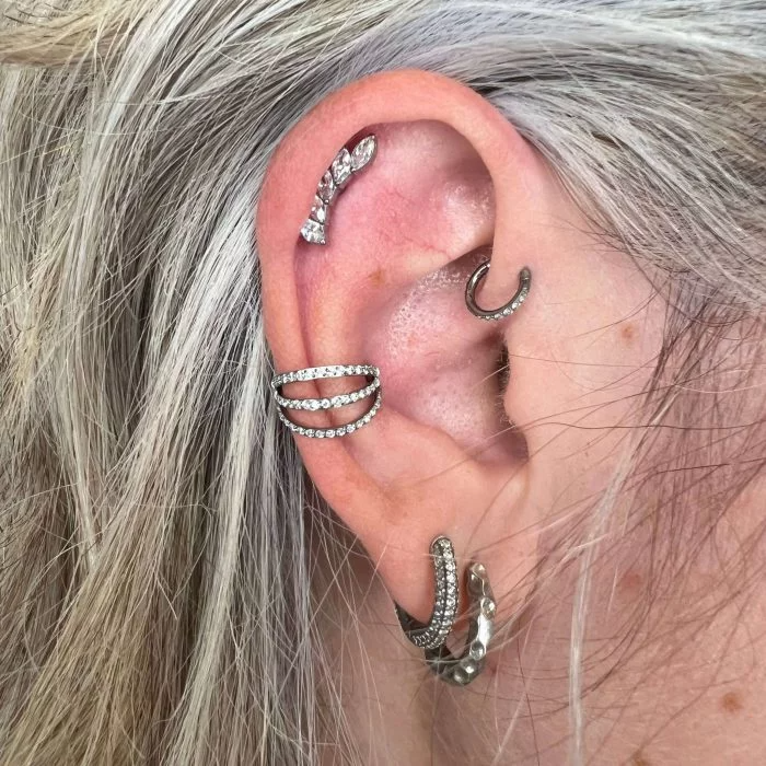 Piercing clicker Triple Queen in titanio di grado implantare – chiusura a scatto e tripla fila decorativa per un look sofisticato.