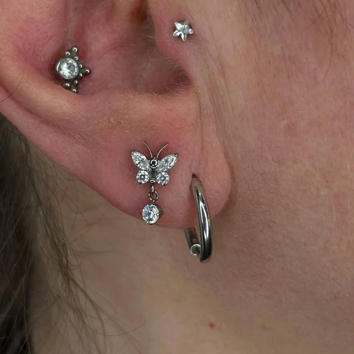 Piercing in titanio ipoallergenico Butterfly Drop, design delicato a farfalla ideale per look femminili e luminosi.