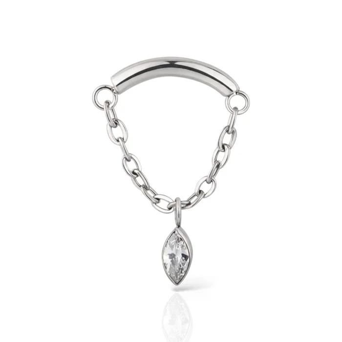 Il piercing “Chain Drop” in titanio unisce luce e movimento: una catena delicata che danza sulla pelle, simbolo di eleganza e libertà.