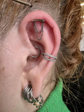 Piercing in titanio leggero con doppia catena decorativa, resistente e dal design raffinato.