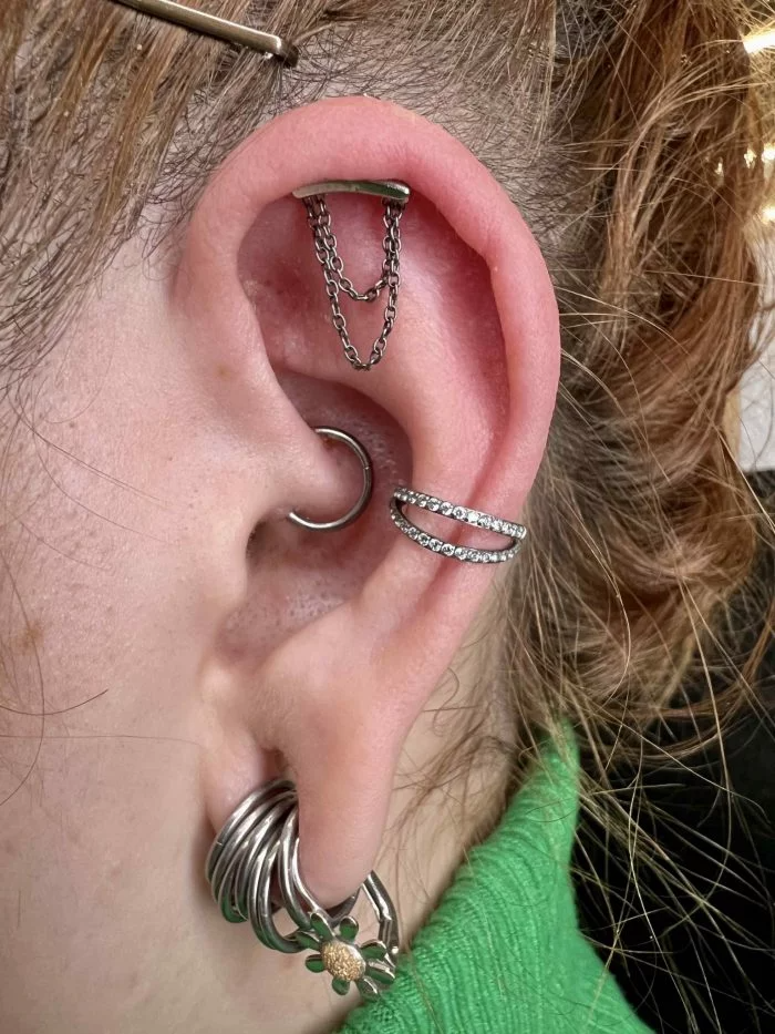 Piercing in titanio leggero con doppia catena decorativa, resistente e dal design raffinato.