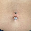 Il suo design a cuore aggiunge un tocco romantico e femminile all’ombelico, valorizzando ogni movimento con una luce discreta e raffinata. Grazie al titanio, questo piercing è leggero, resistente e durevole, garantendo massima comodità anche durante l’uso quotidiano.