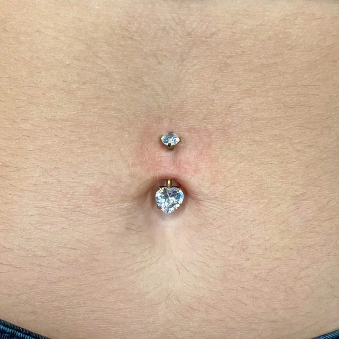 Il suo design a cuore aggiunge un tocco romantico e femminile all’ombelico, valorizzando ogni movimento con una luce discreta e raffinata. Grazie al titanio, questo piercing è leggero, resistente e durevole, garantendo massima comodità anche durante l’uso quotidiano.