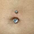 Il suo design a cuore aggiunge un tocco romantico e femminile all’ombelico, valorizzando ogni movimento con una luce discreta e raffinata. Grazie al titanio, questo piercing è leggero, resistente e durevole, garantendo massima comodità anche durante l’uso quotidiano.