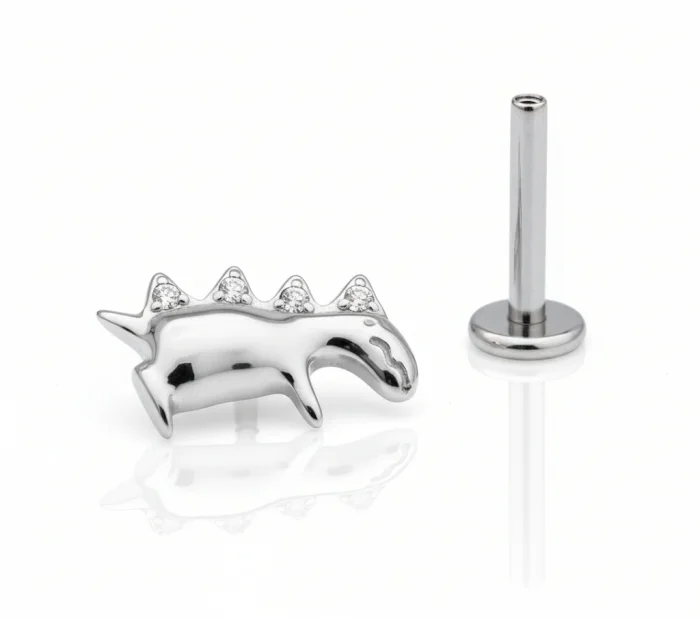 Gioiello piercing in titanio con piccolo dinosauro, elegante e adatto a look originali su helix e lobo.
