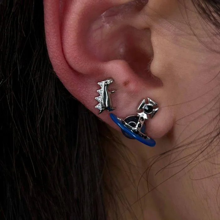 Gioiello piercing in titanio con piccolo dinosauro, elegante e adatto a look originali su helix e lobo.