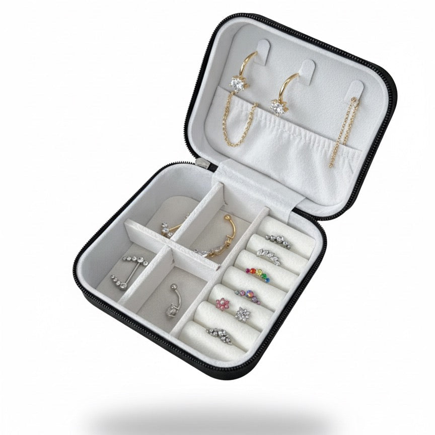 Porta gioielli Noa Ink Case nero opaco aperto, con orecchini e piercing all’interno. Design minimal e compatto con logo Noa Ink inciso, ideale per conservare e presentare gioielli in modo ordinato ed elegante.