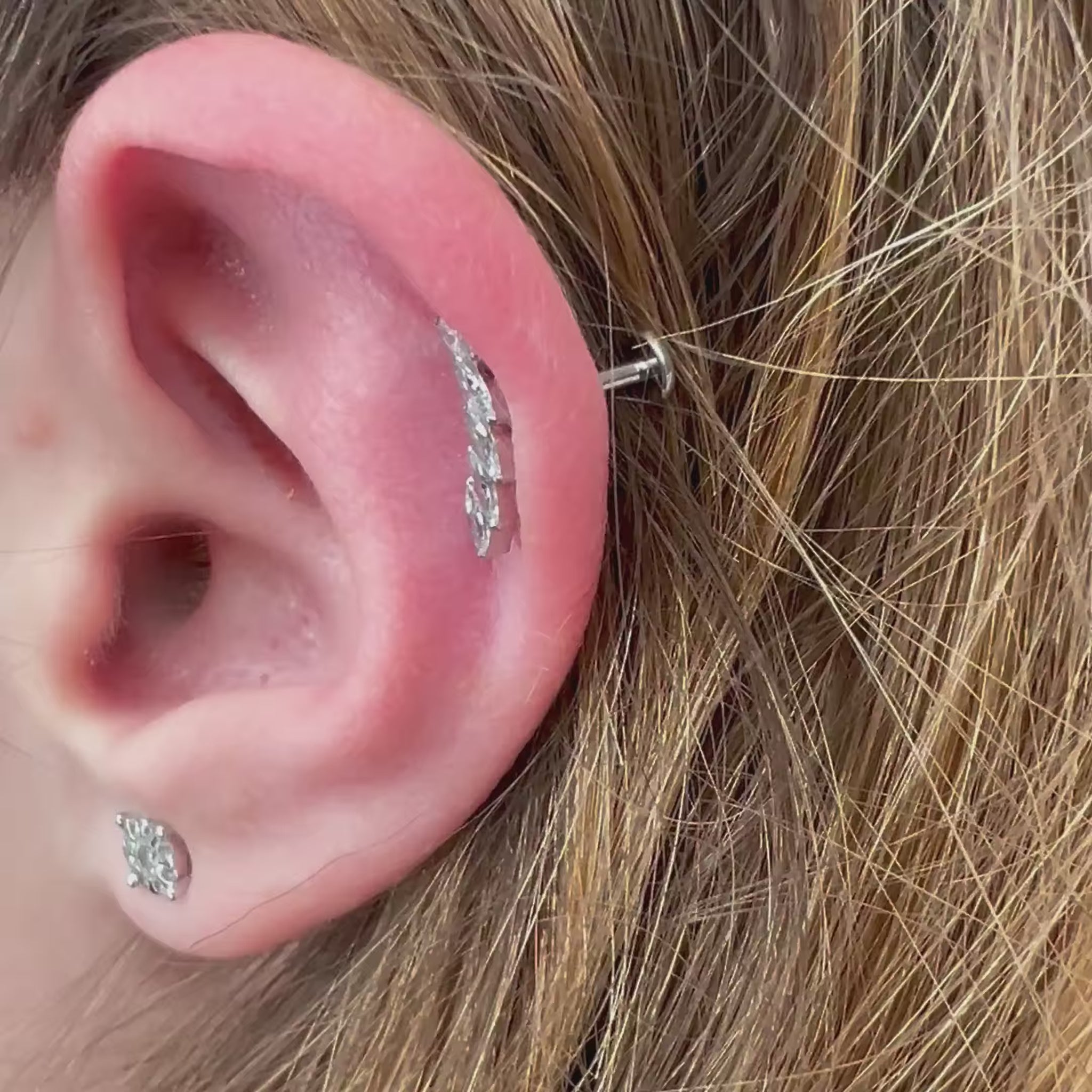 Gioiello indossato piercing Foglia (Leaf) minimalista in Titanio Chirurgico. Design elegante a forma di foglia, leggero e anallergico, eccellente per un look discreto su helix o conch.