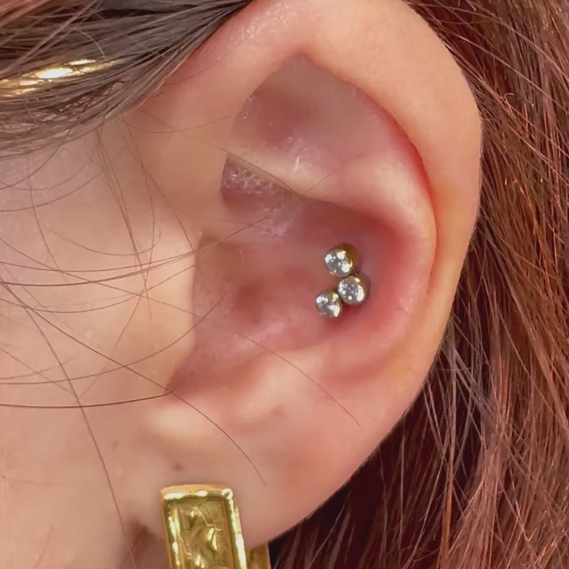 Piercing in titanio ipoallergenico con tre micro cristalli a cluster, ideale per look discreti e luminosi.