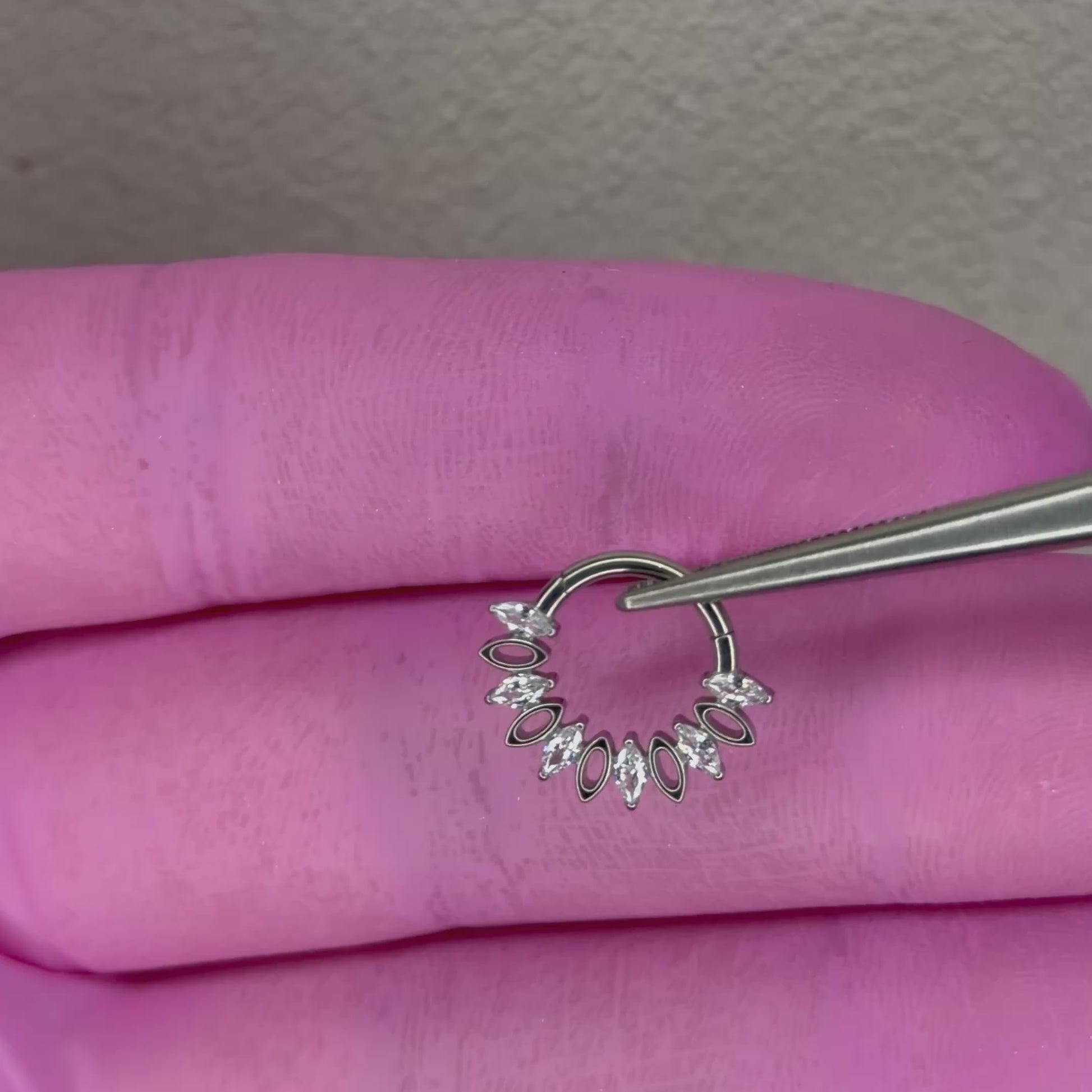 Piercing clicker elegante per septum e daith con zirconi taglio marquise e design raffinato. Realizzato in titanio, resistente, anallergico e perfetto per un look luminoso e sofisticato.