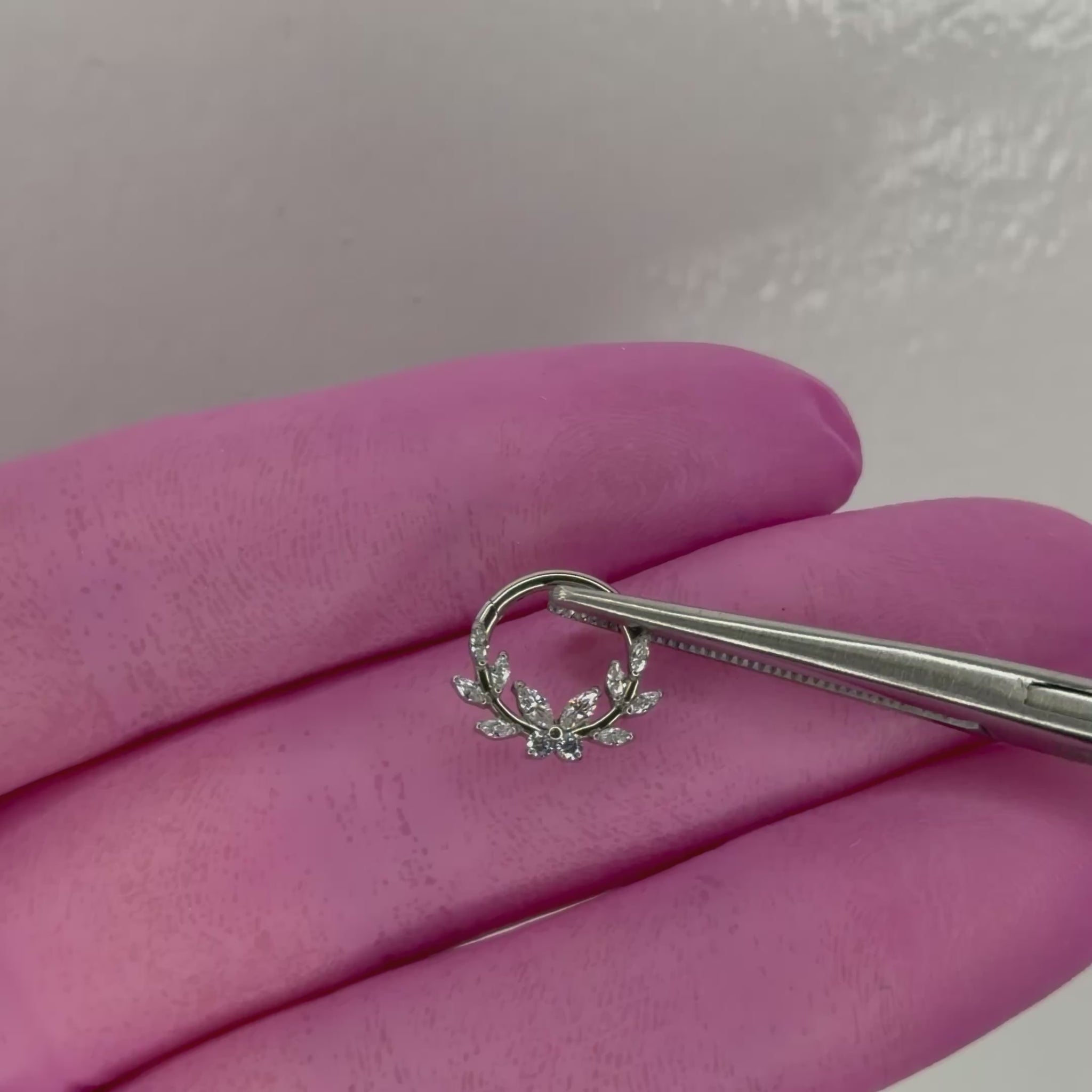 Piercing Branch Clicker in titanio ASTM F136 con zirconi taglio marquise. Design ispirato ai rami e alle foglie, ideale per daith e septum. Leggero, biocompatibile e brillante.