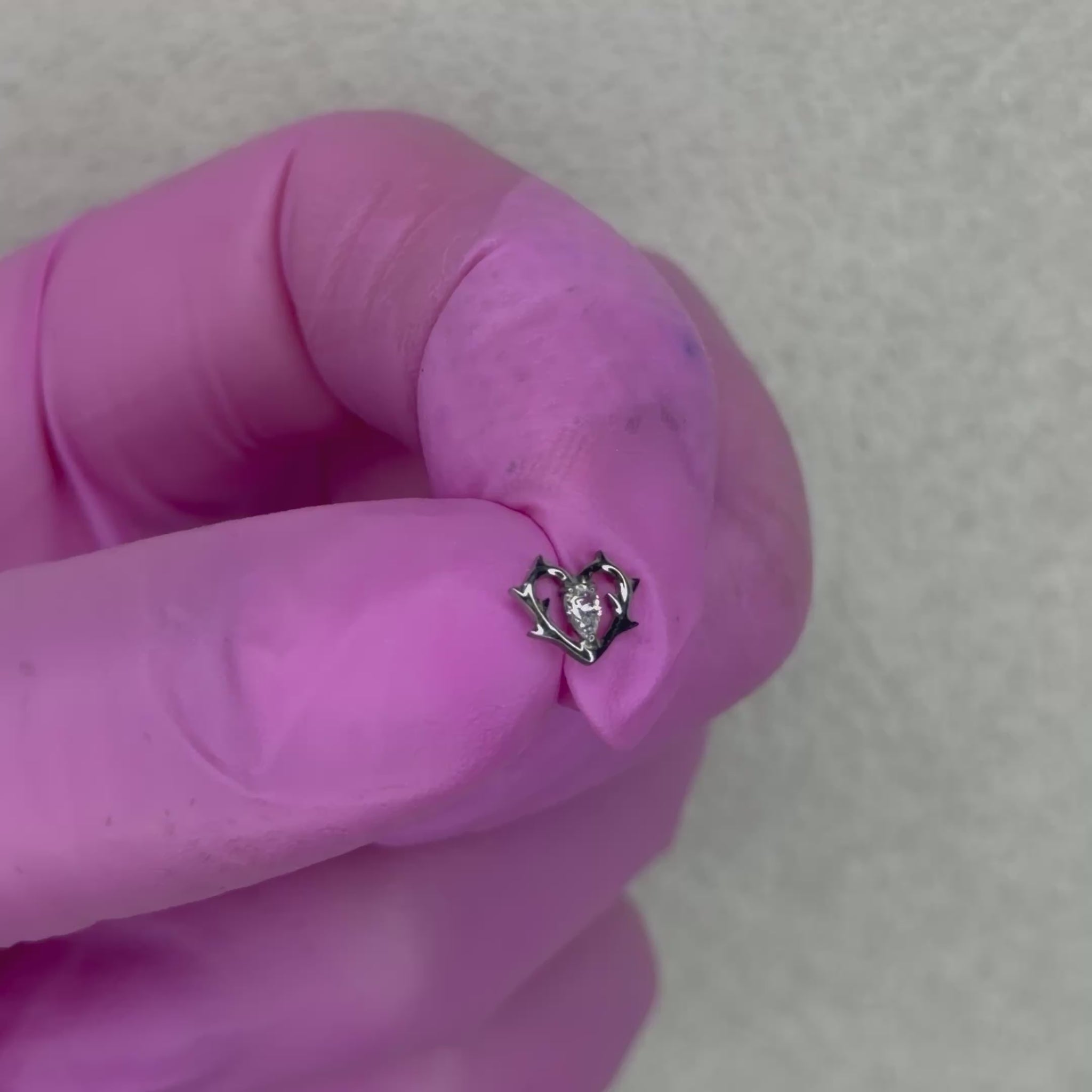 Gioiello per piercing realizzato in titanio, caratterizzato da un elegante design a cuore con dettagli effetto ali e piccoli cristalli luminosi. Un modello romantico e originale, perfetto per valorizzare diversi piercing dell’orecchio con un tocco delicato ma particolare.