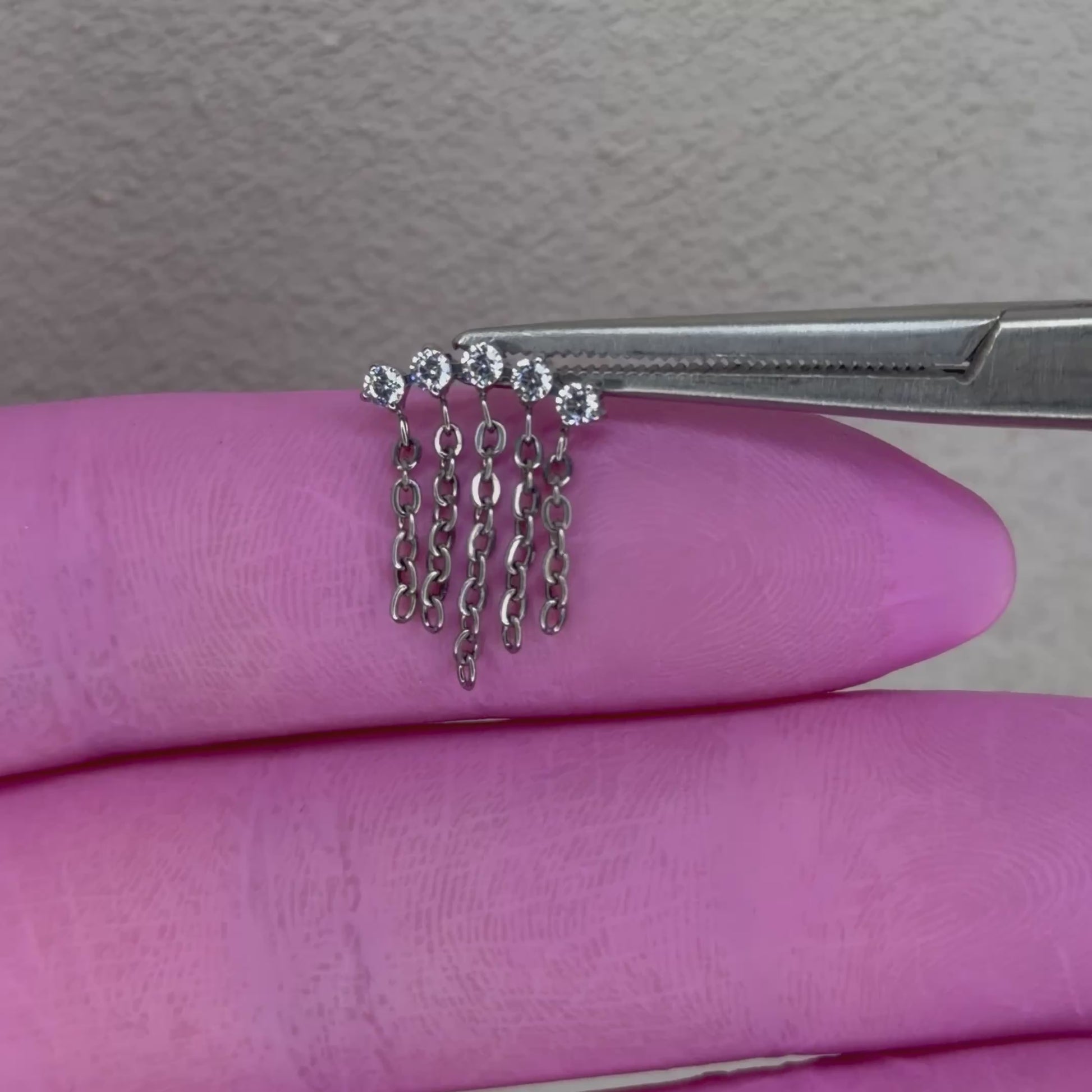 Terminale piercing in titanio ASTM F136 con stelle impreziosite da zirconi e catenelle pendenti. Ideale per lobo e flat. Ipoallergenico, nickel free e perfetto per un look elegante e originale.