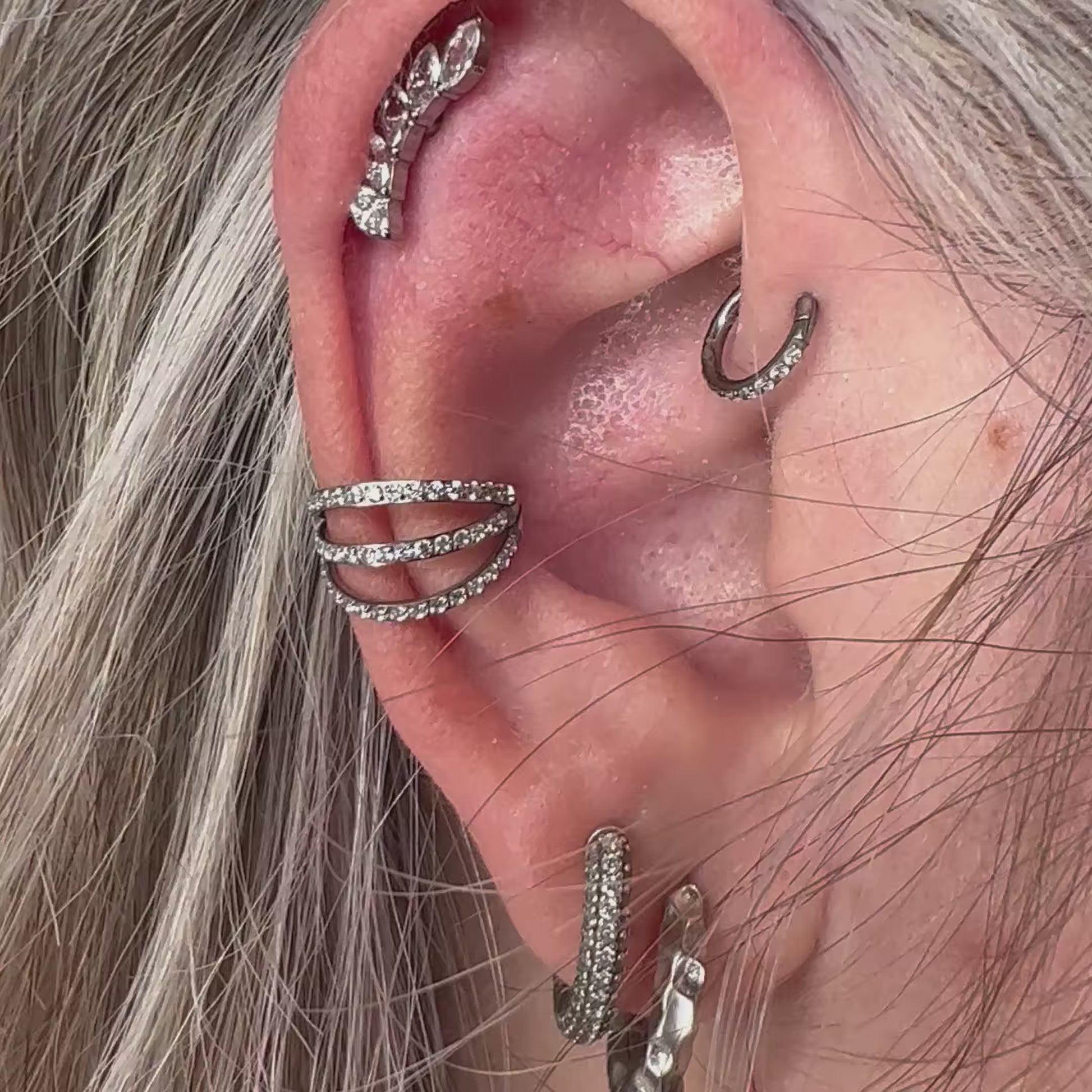 Piercing clicker Triple Queen in titanio di grado implantare – chiusura a scatto e tripla fila decorativa per un look sofisticato.