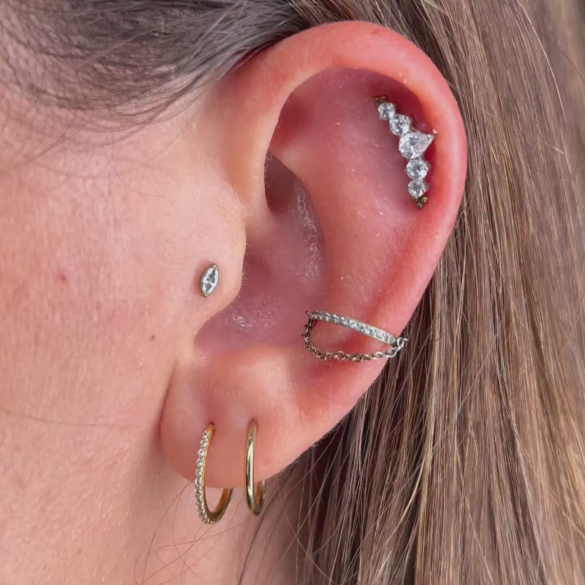 Cerchietto clicker (hinged ring) in titanio di grado implantare, con catenella pendente (Bright Clicker Chain). Chiusura a scatto, anello con dettaglio catena