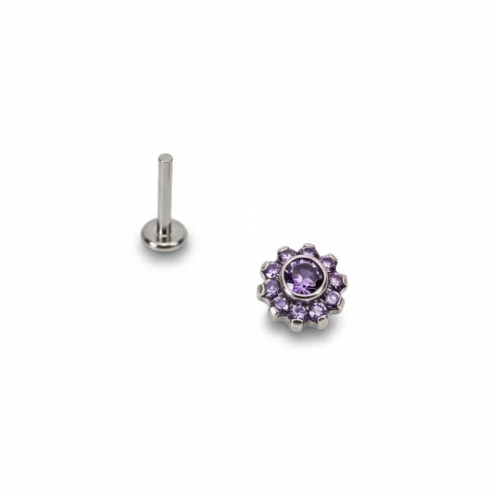 Piercing “Shiny Flower” in titanio lucente con petali di cristalli luminosi. Un gioiello delicato e scintillante, perfetto per chi ama un look femminile e raffinato.