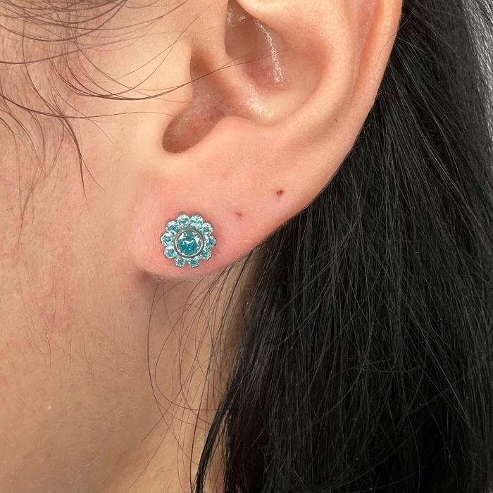 Piercing “Shiny Flower” in titanio lucente con petali di cristalli luminosi. Un gioiello delicato e scintillante, perfetto per chi ama un look femminile e raffinato.