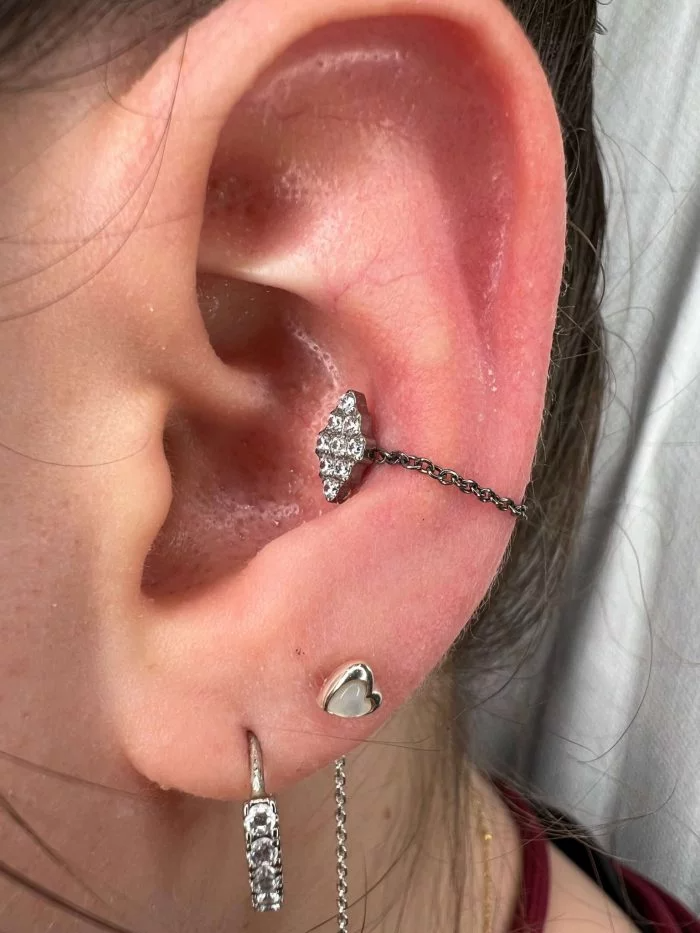 Piercing in titanio ipoallergenico con cristallo rombo brillante, ideale per look minimal e luminosi.