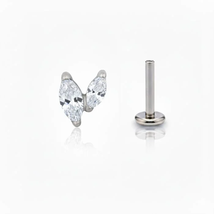 Piercing in titanio ipoallergenico con design minimal a V e cristallo marquise brillante.